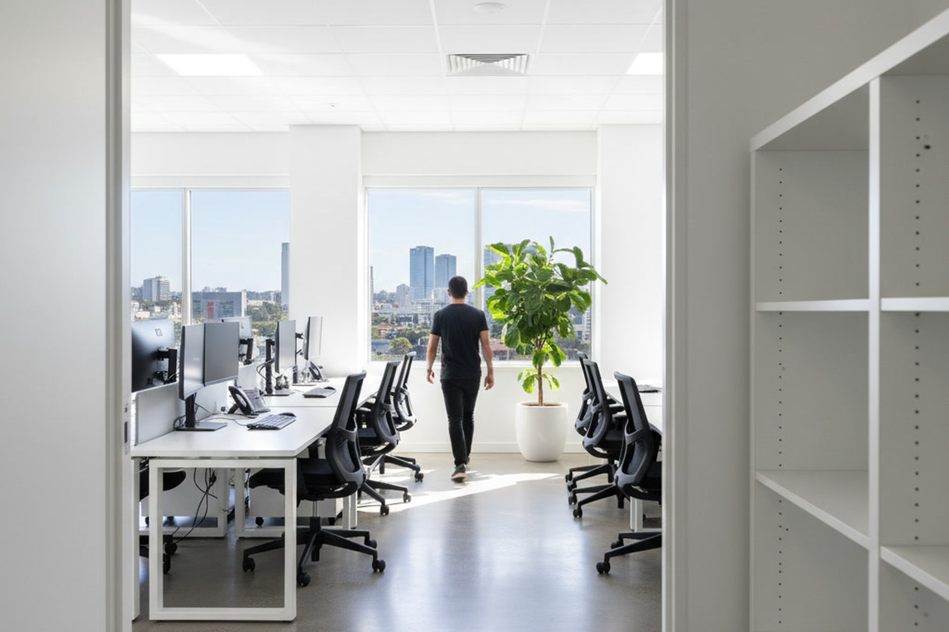 A small software office in Brisbane at the start of the day, seen from behind as one person walks in.