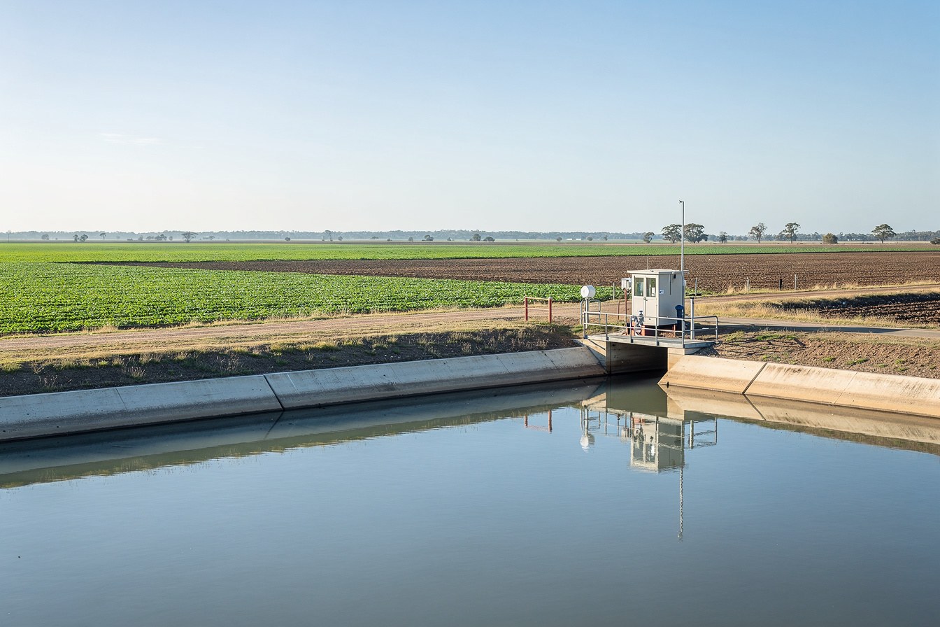 A quiet irrigation channel and water gauge on a border river, standing for a notice that looks like one thing but is really about buying water rights.